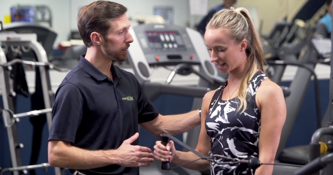 Physical therapist talking with a woman in a gym