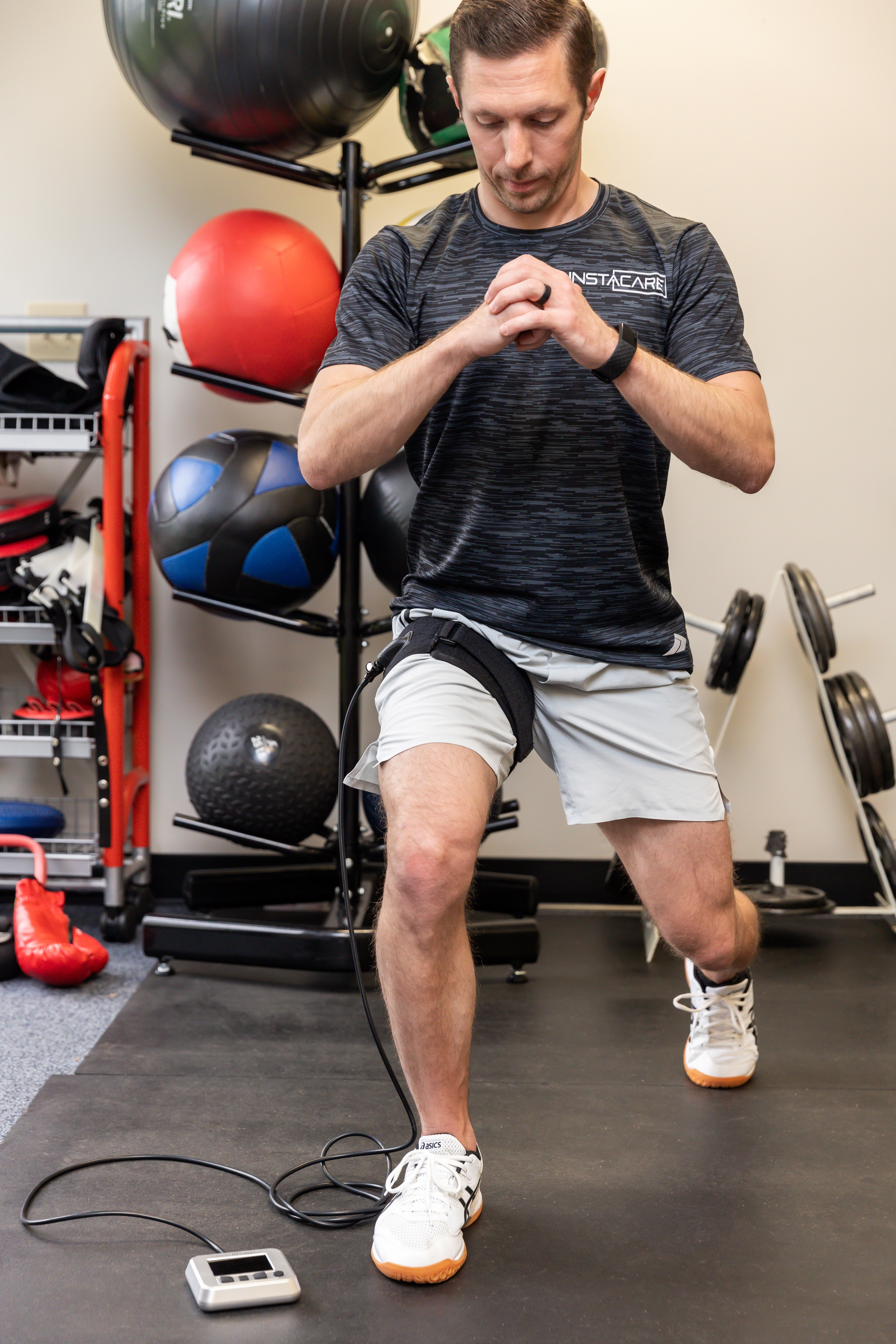 Man doing a split squat with blood flow restriction cuffs on his thighs